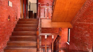 Eine Holztreppe mit einer Backsteinmauer an einer Seite und einer Holzplattform an der anderen.