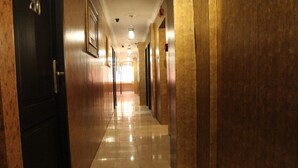 Un long couloir étroit, doté d’un plancher ciré et de murs en bois.