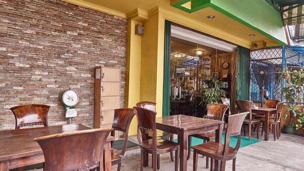 Un restaurant avec des meubles en bois, un mur en briques et un plafond vert.