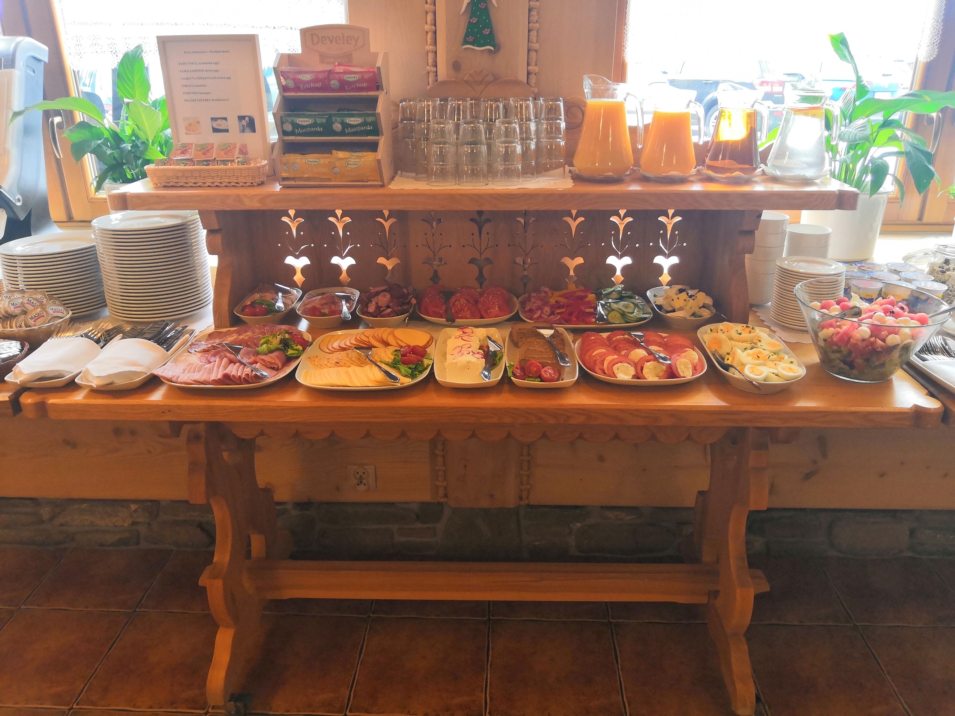A buffet table with various food items and condiments.