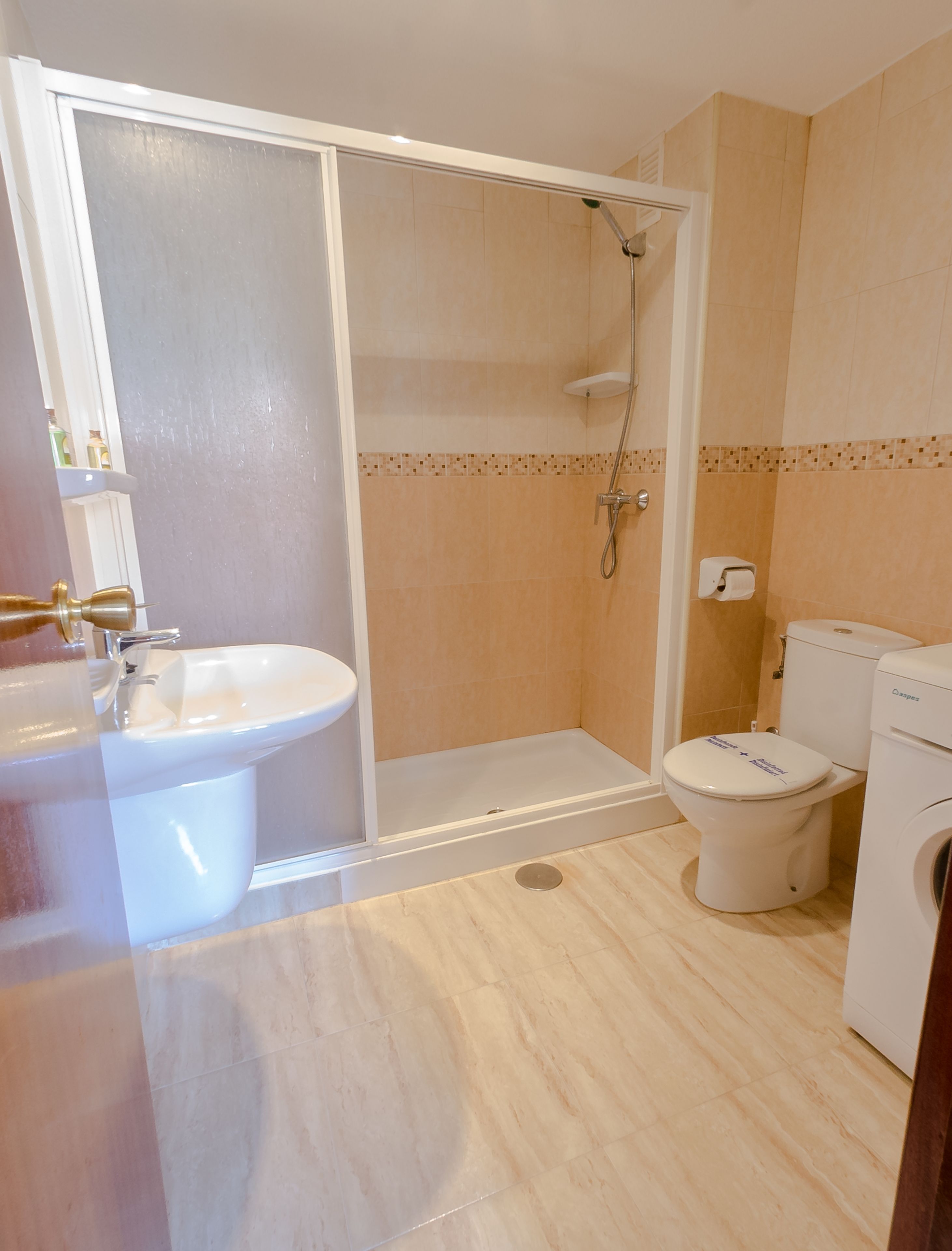 Un baño con ducha, inodoro y lavamanos.