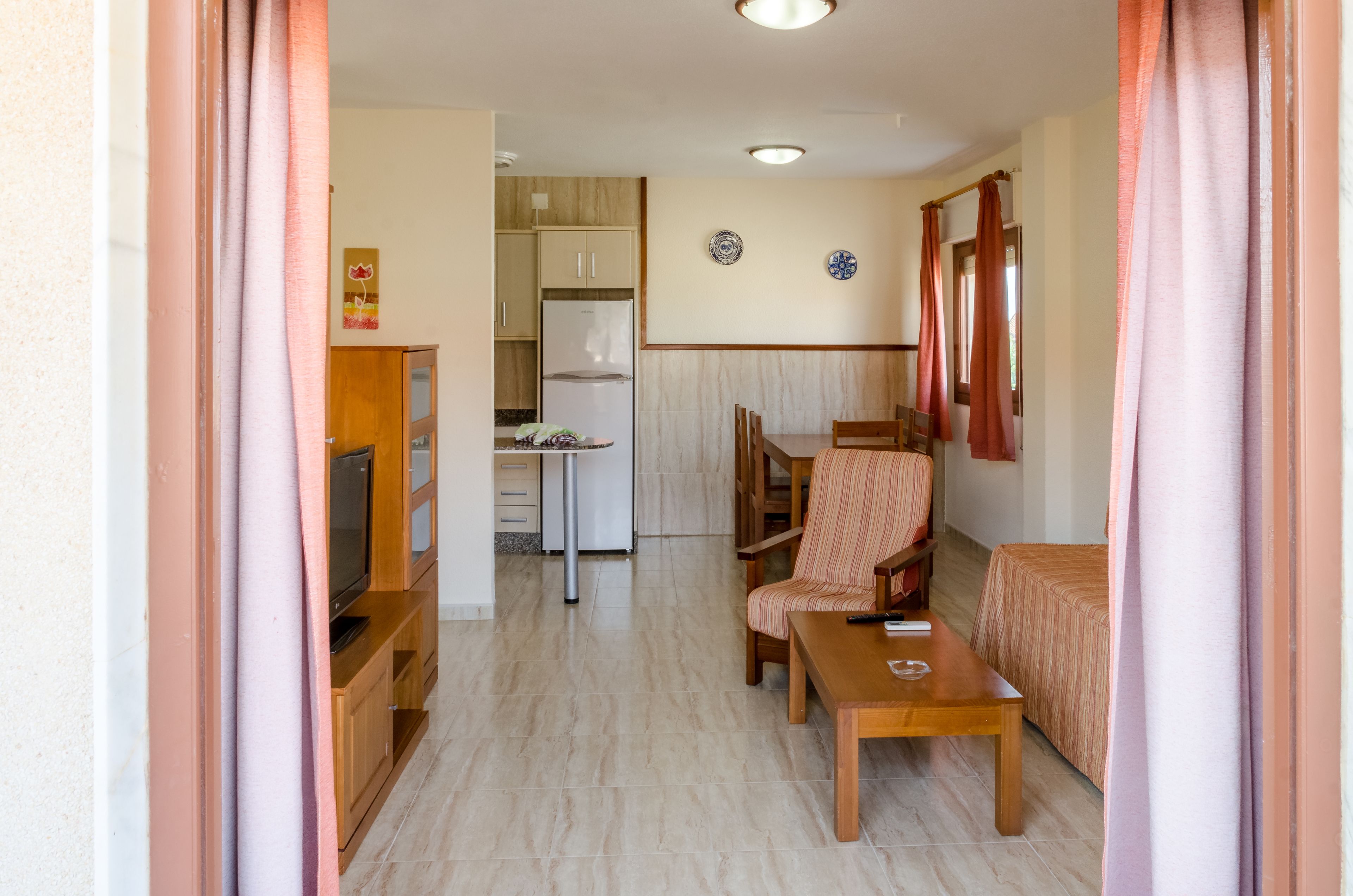 A compact living space with a kitchenette, a dining area, and a seating area.