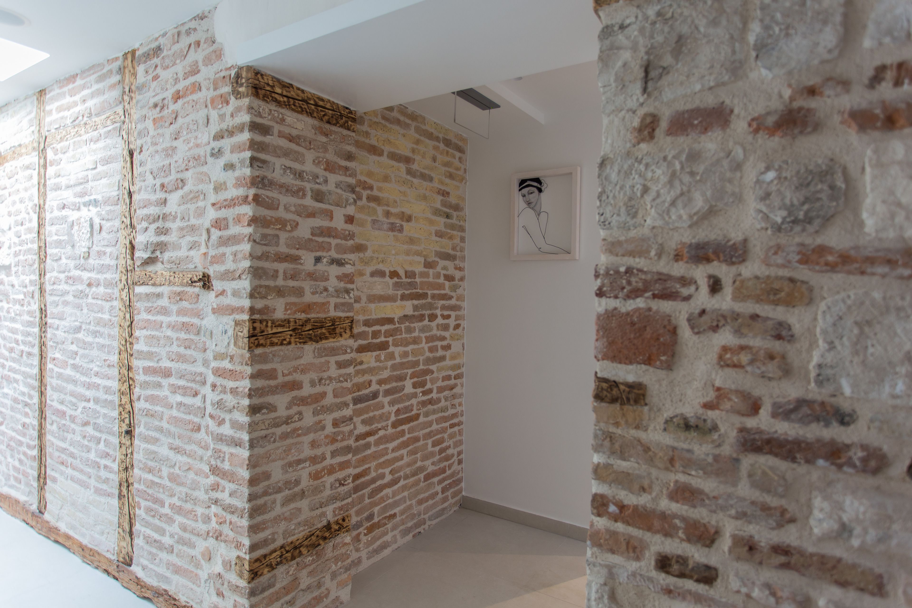 A room with exposed brick walls and a white ceiling.