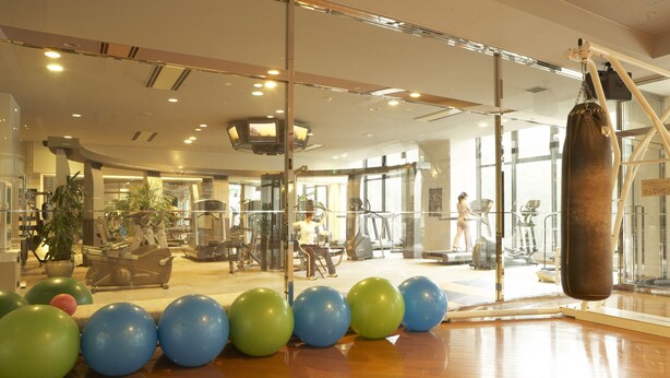 A gym with exercise equipment, a punching bag, and exercise balls. - Seagaia Forest Cottages (Miyazaki)