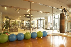 A gym with exercise equipment, a punching bag, and exercise balls. - Seagaia Forest Cottages (Miyazaki)