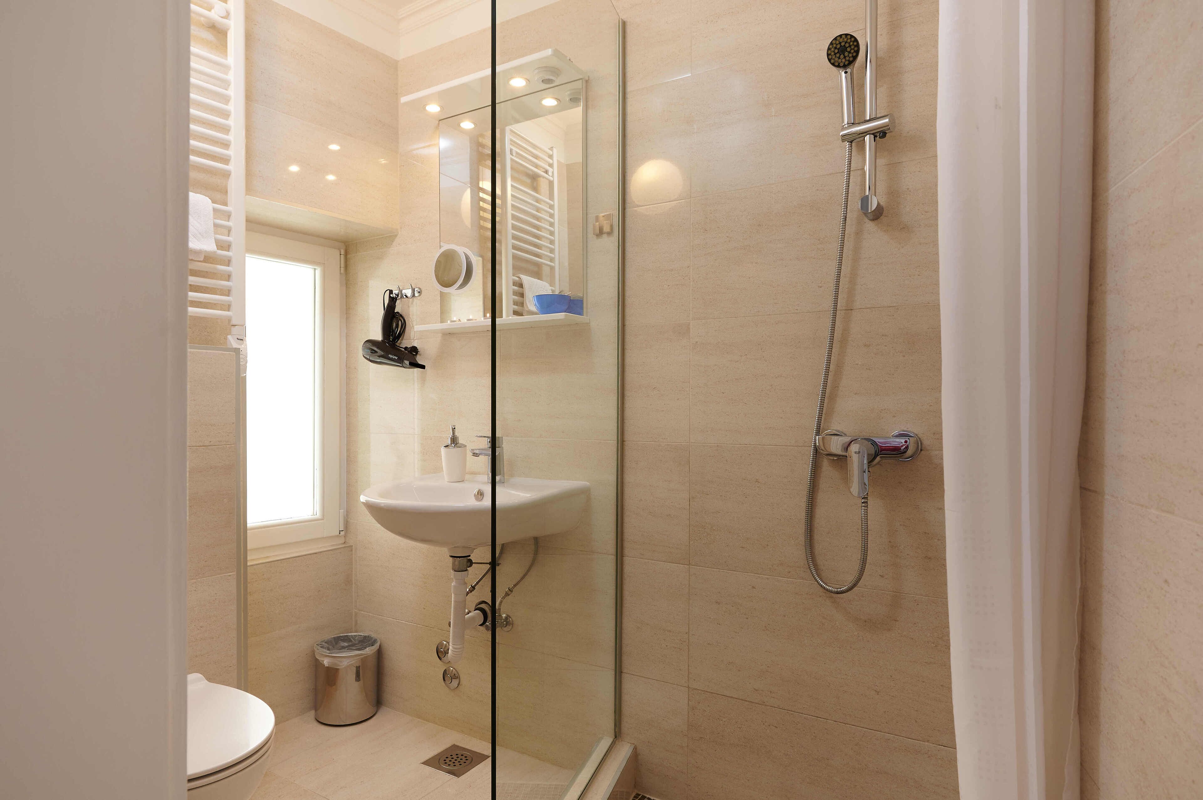 A modern bathroom with a glass shower enclosure, a sink, and a toilet.