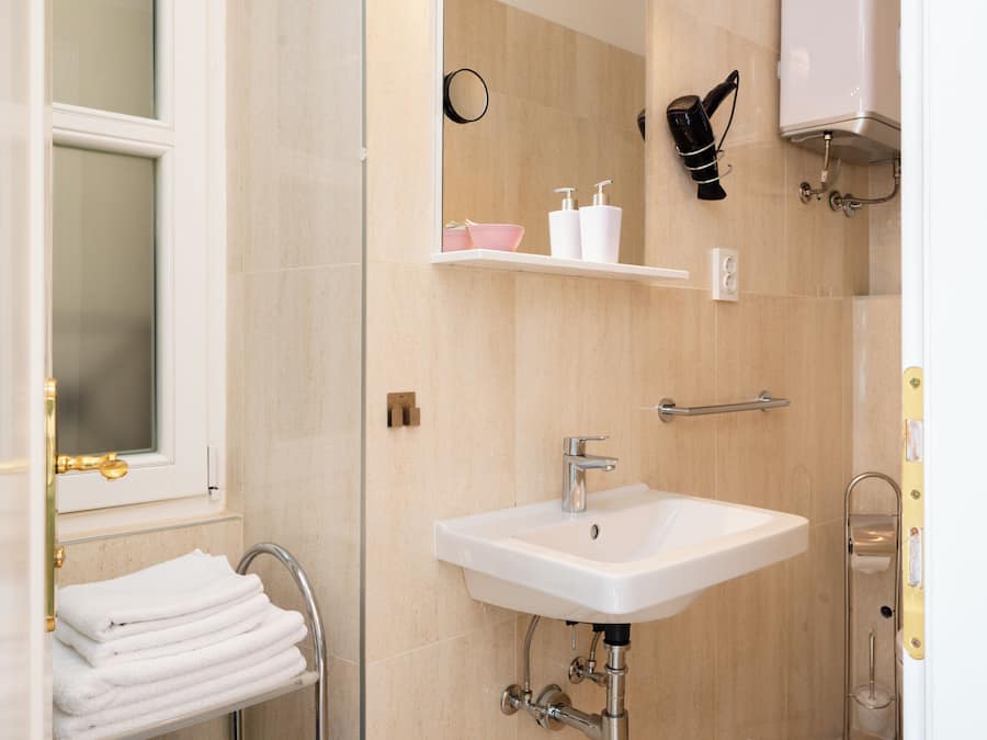 Een badkamer met een wastafel, handdoekhouder en spiegel.