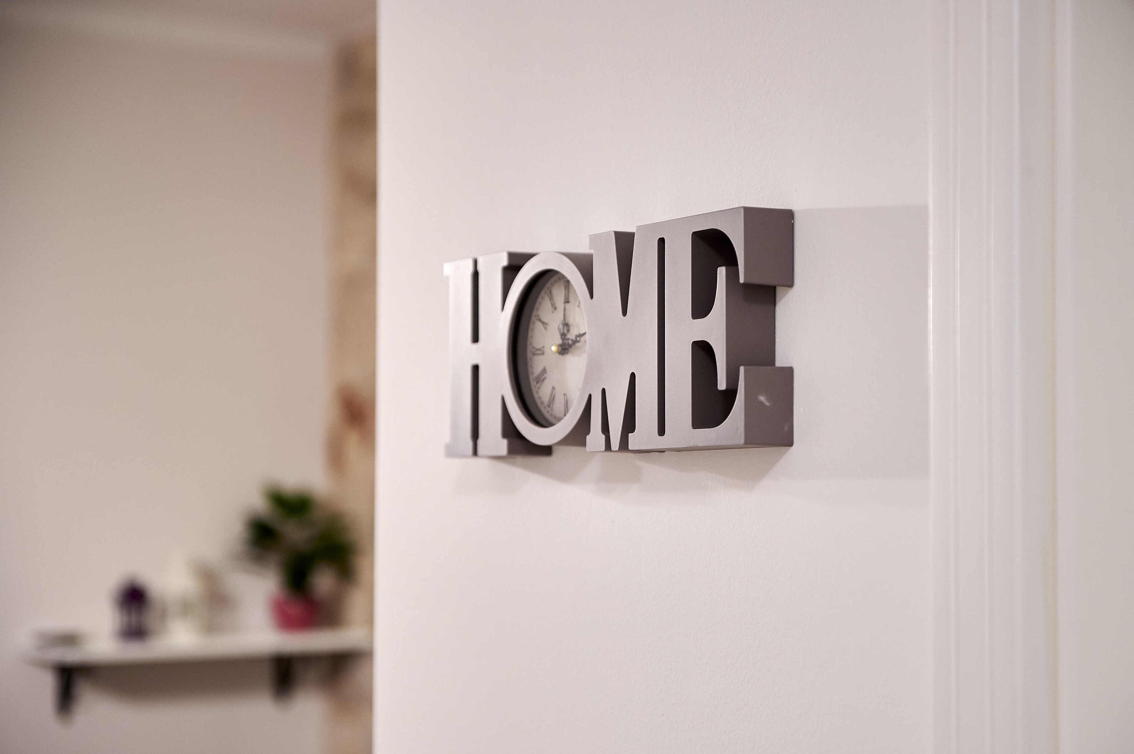 A wall-mounted sign with the word "HOME" in large, metallic letters.