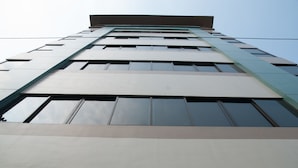 A tall building with a modern architectural design, featuring a series of windows and a flat roof. - M Suites Hotel (Makati)