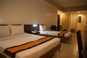 A hotel room with two beds, a desk, and a chair. - M Suites Hotel (Makati)