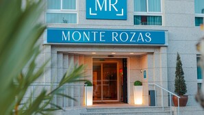Entrada de un hotel con un letrero que dice "MR Monte Rozas".