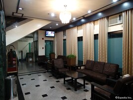 Un vestíbulo con sofá, sillas, una mesa de centro, televisor y una escalera.
