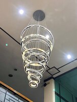 Ein Kronleuchter aus Kristall und Metall mit mehreren Etagen, der von der Decke hängt.