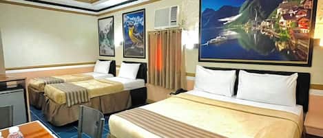 Habitación de hotel con dos camas, un escritorio, sillas y obras de arte en las paredes.