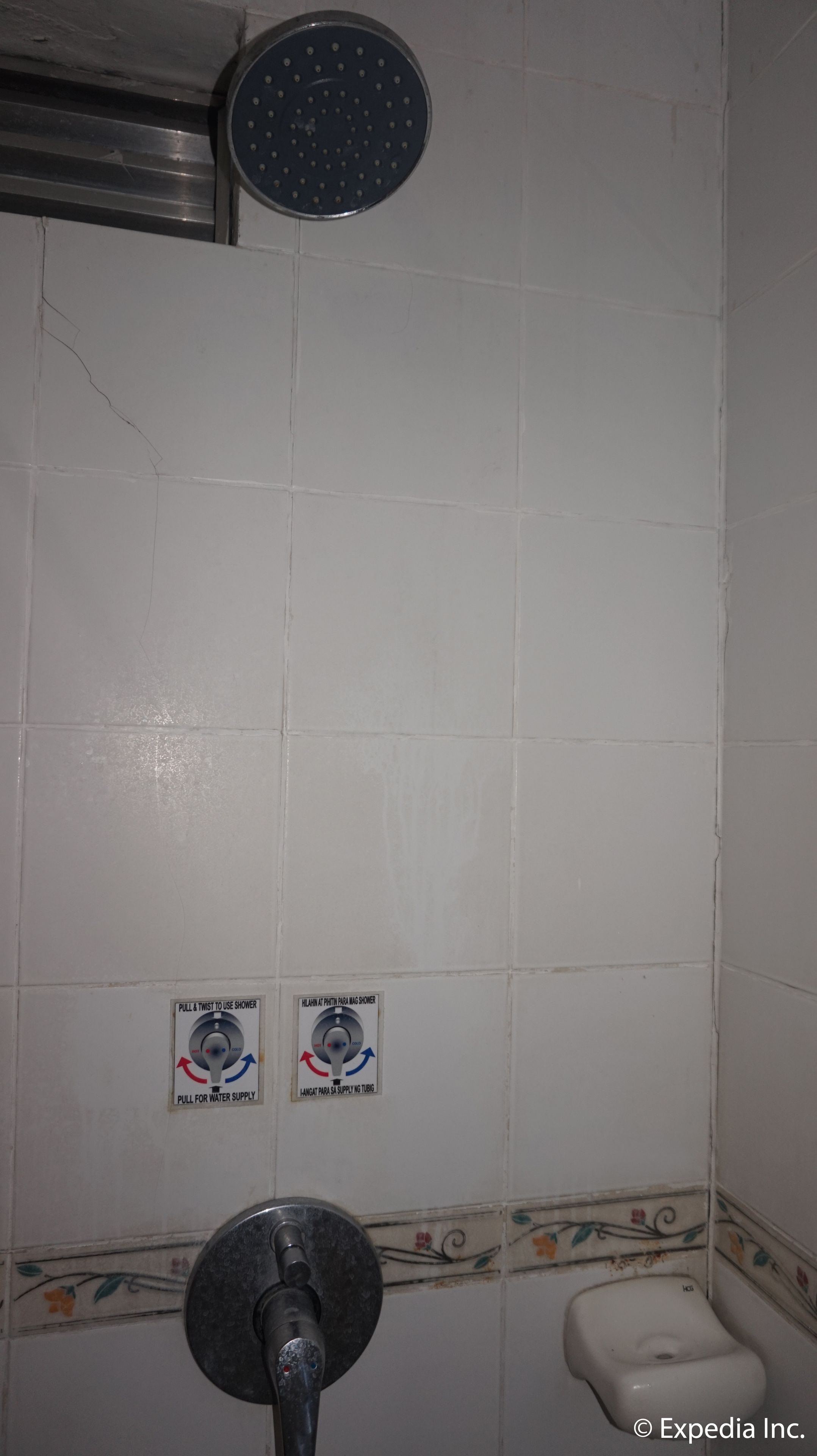 A bathroom with a shower, toilet, and water supply instructions.