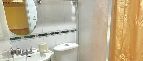A bathroom with a sink, toilet, and shower curtain.