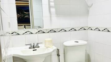 A bathroom with a sink, toilet, and a towel rack.