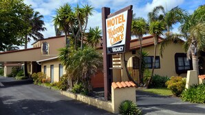 A motel named 'Hobson's Choice' with a 'VACANCY' sign, surrounded by palm trees and a clear sky. - Motel Hobson's Choice (Dargaville)