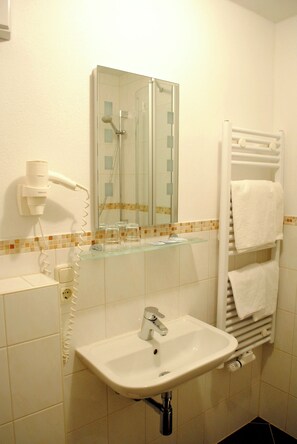 Habitación estándar doble | Baño | Ducha, secador de pelo, toallas y jabón