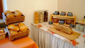 Una taula de buffet amb diferents paït, pastissos i condiments.