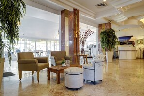 A spacious lobby with a marble floor, seating arrangements, and large windows allowing natural light. - Residence Beach (Netanya)