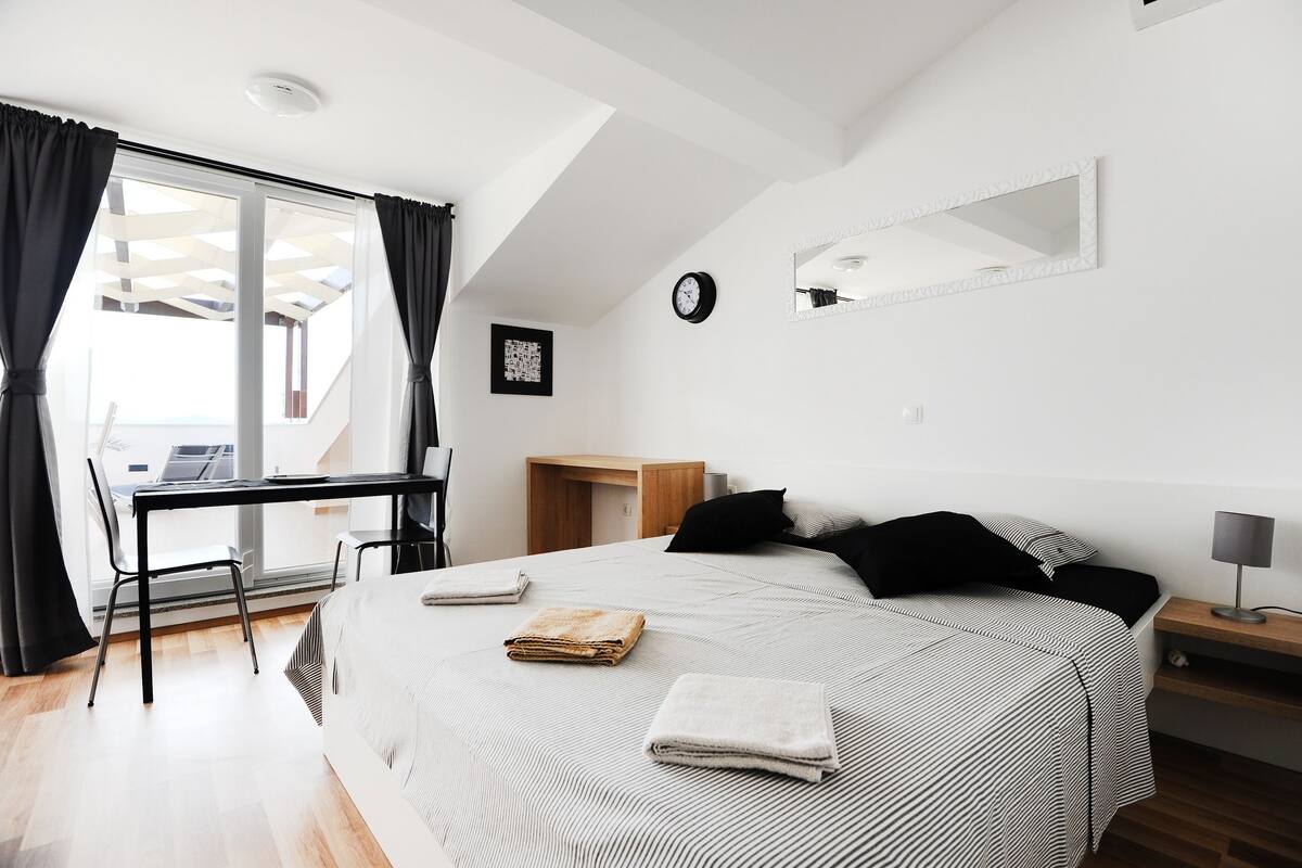 Une chambre à coucher moderne avec un grand lit, un bureau et une chaise.