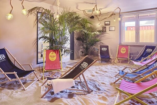 Una habitación con sillas de playa y una planta grande en maceta.