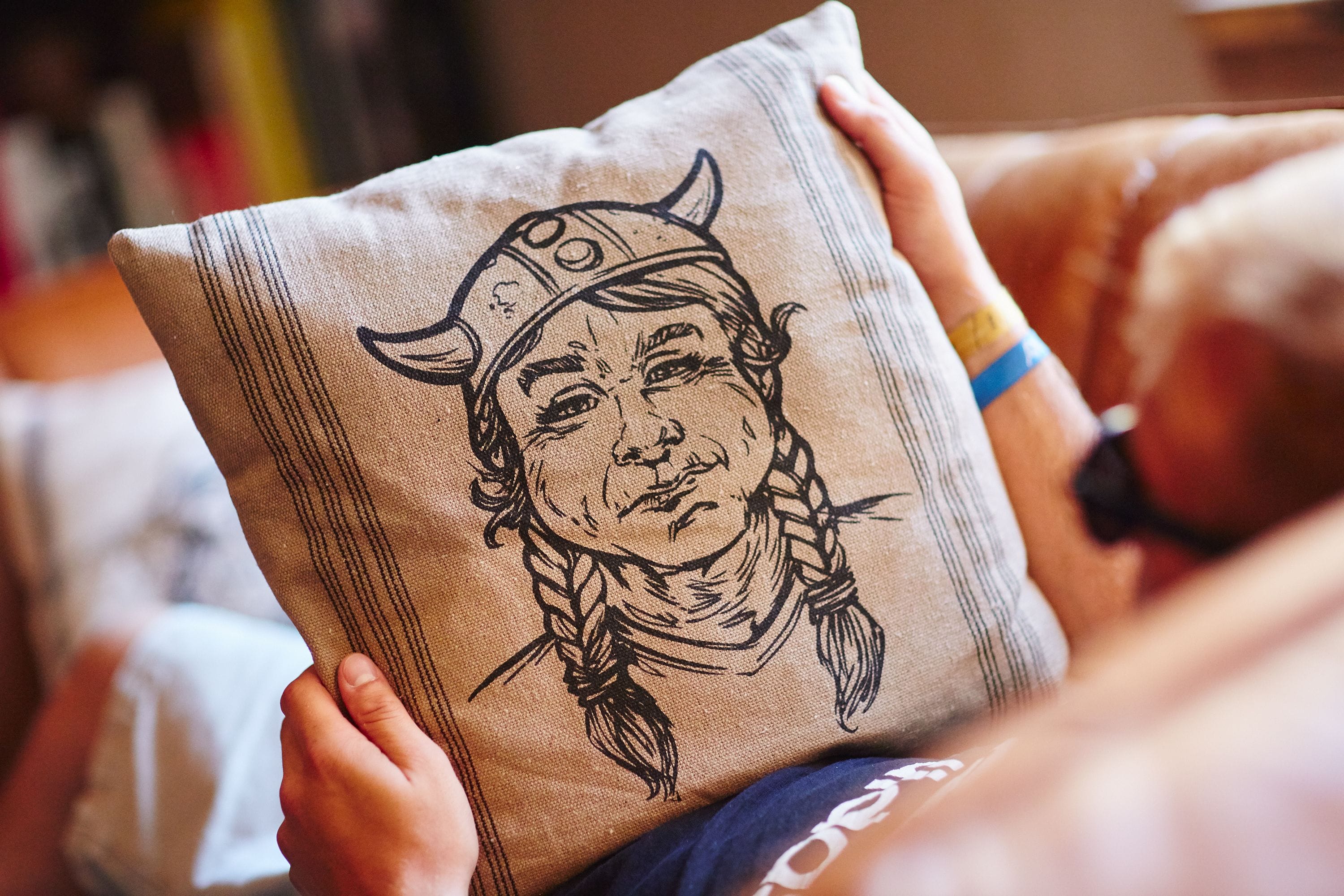 Ein Kissen mit einer Zeichnung von einer Person mit Hut und Bandana.