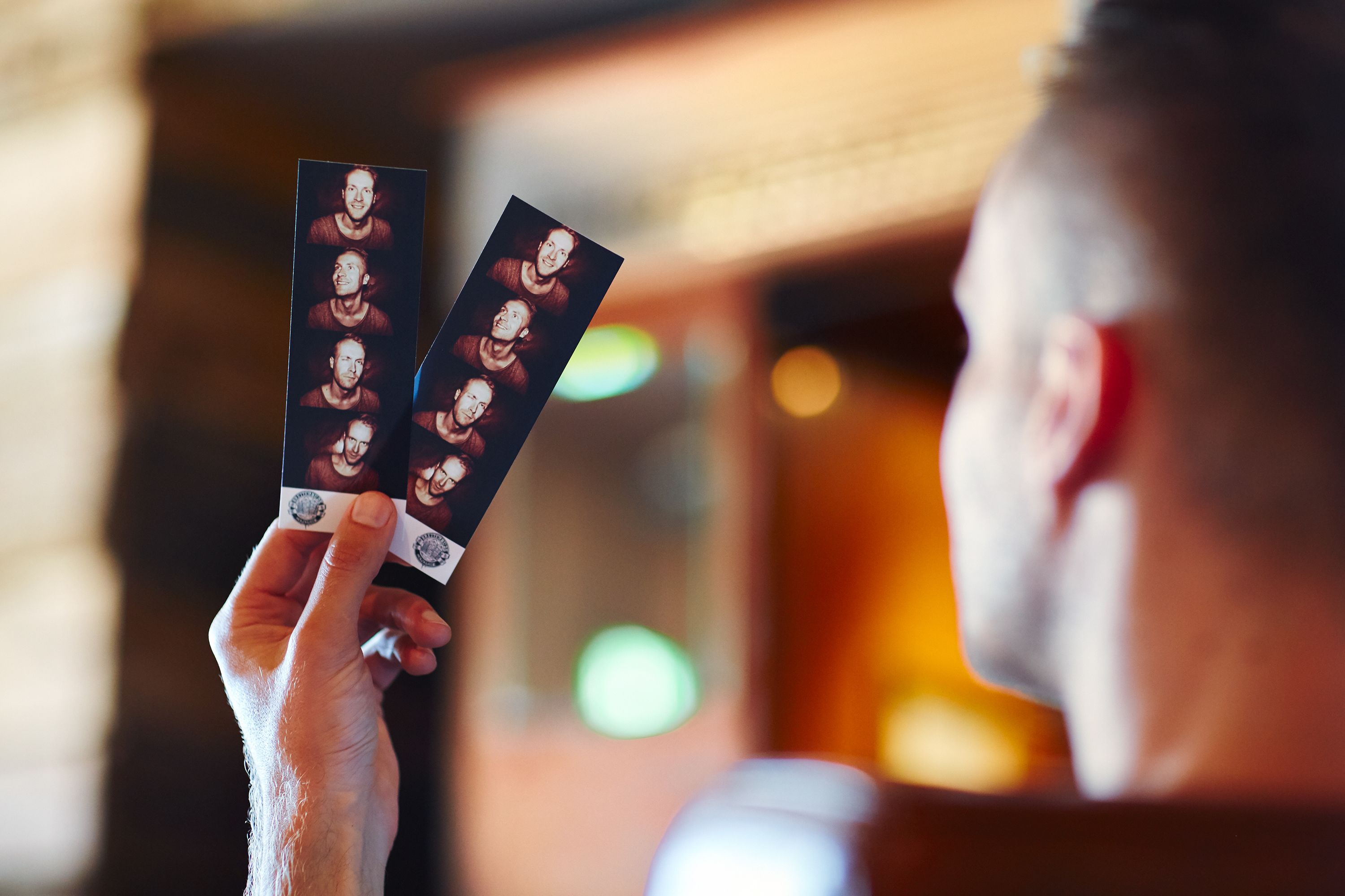 Eine Person hält zwei Fotos.