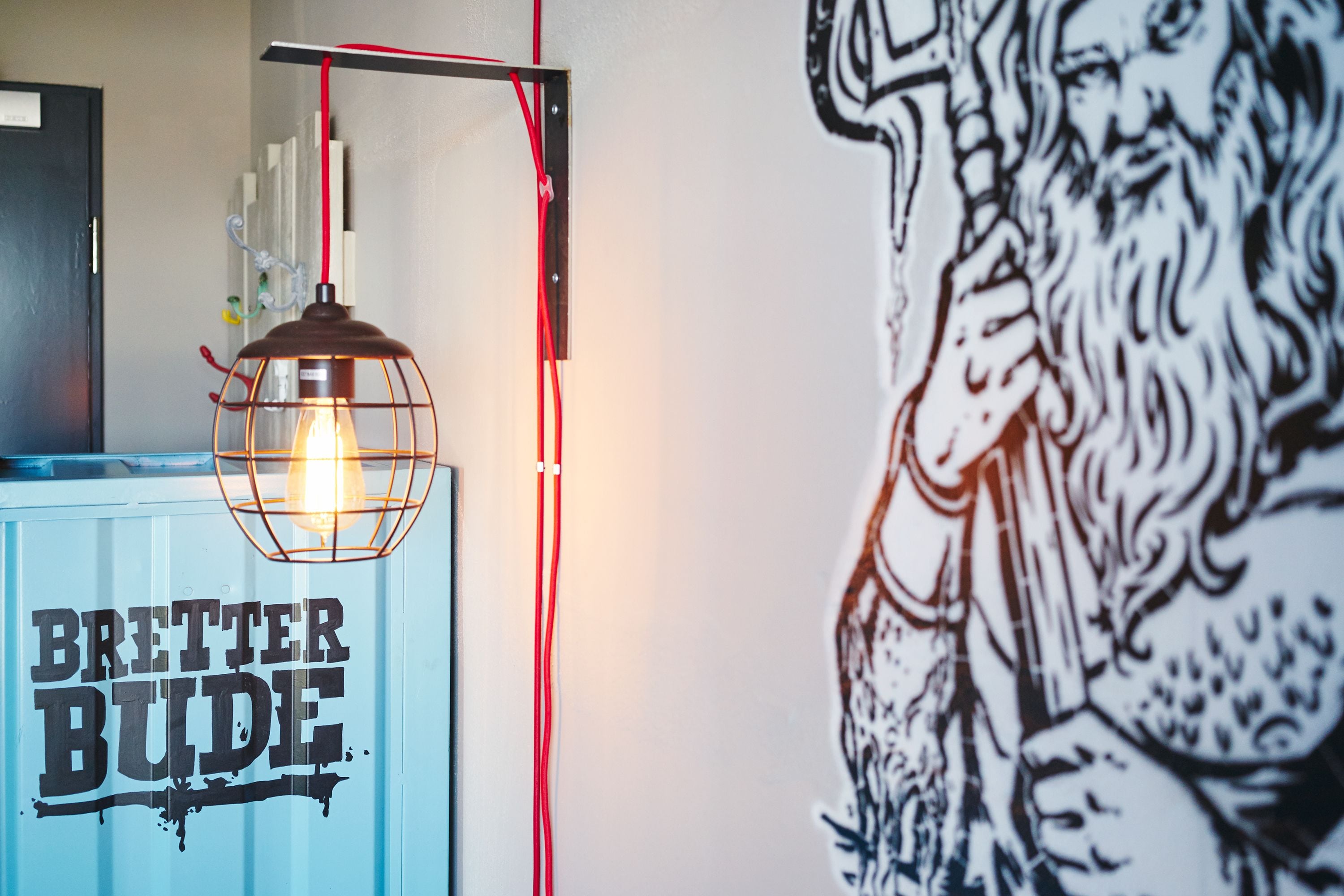 A room with a blue cabinet labeled "BRETTER BUDE" and a wall mural.