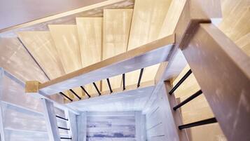 Eine moderne Treppe mit Holzboden und schwarzen Geländern.