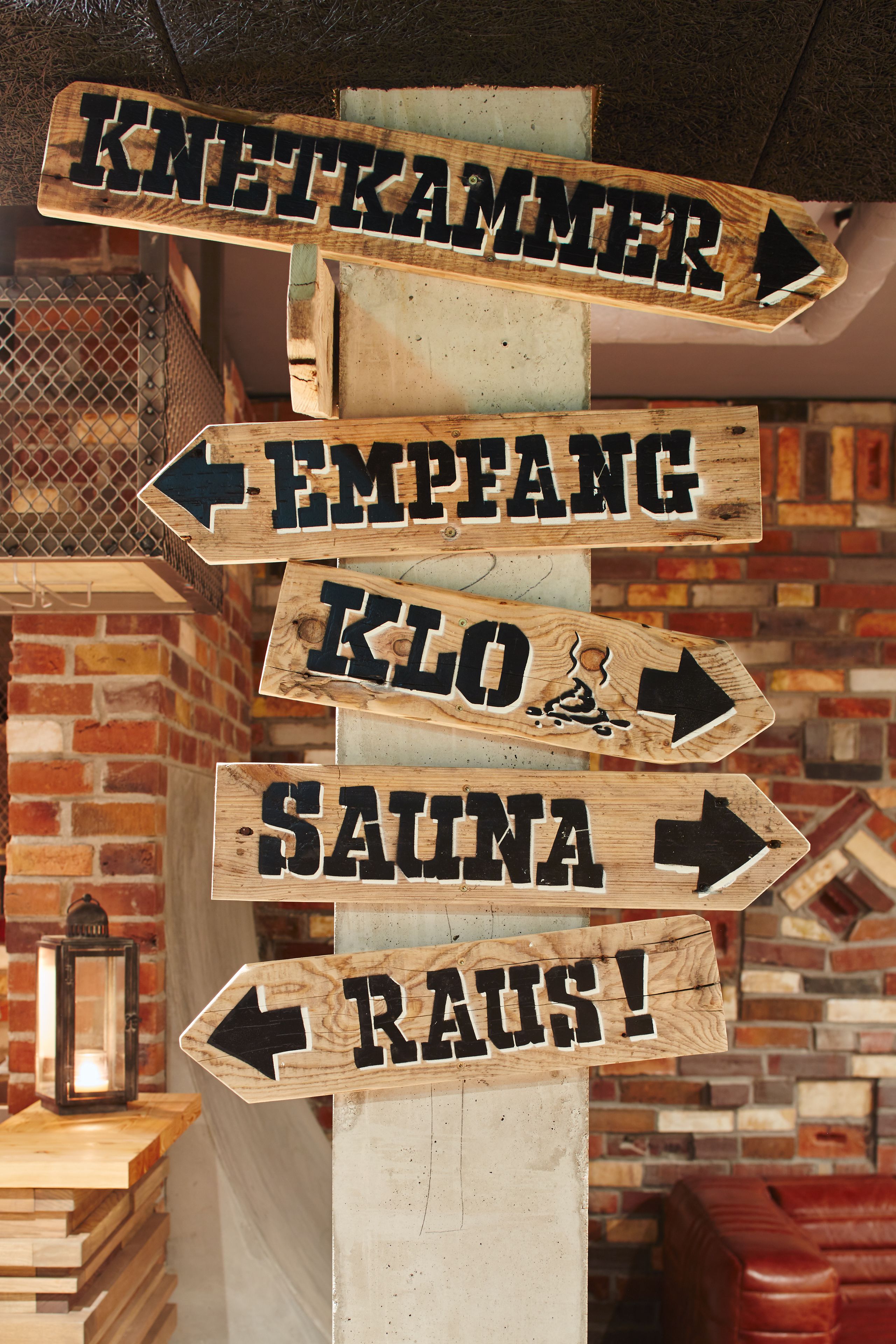 A wooden signpost with directional arrows pointing to various amenities such as a sauna, a spa, and a sauna.