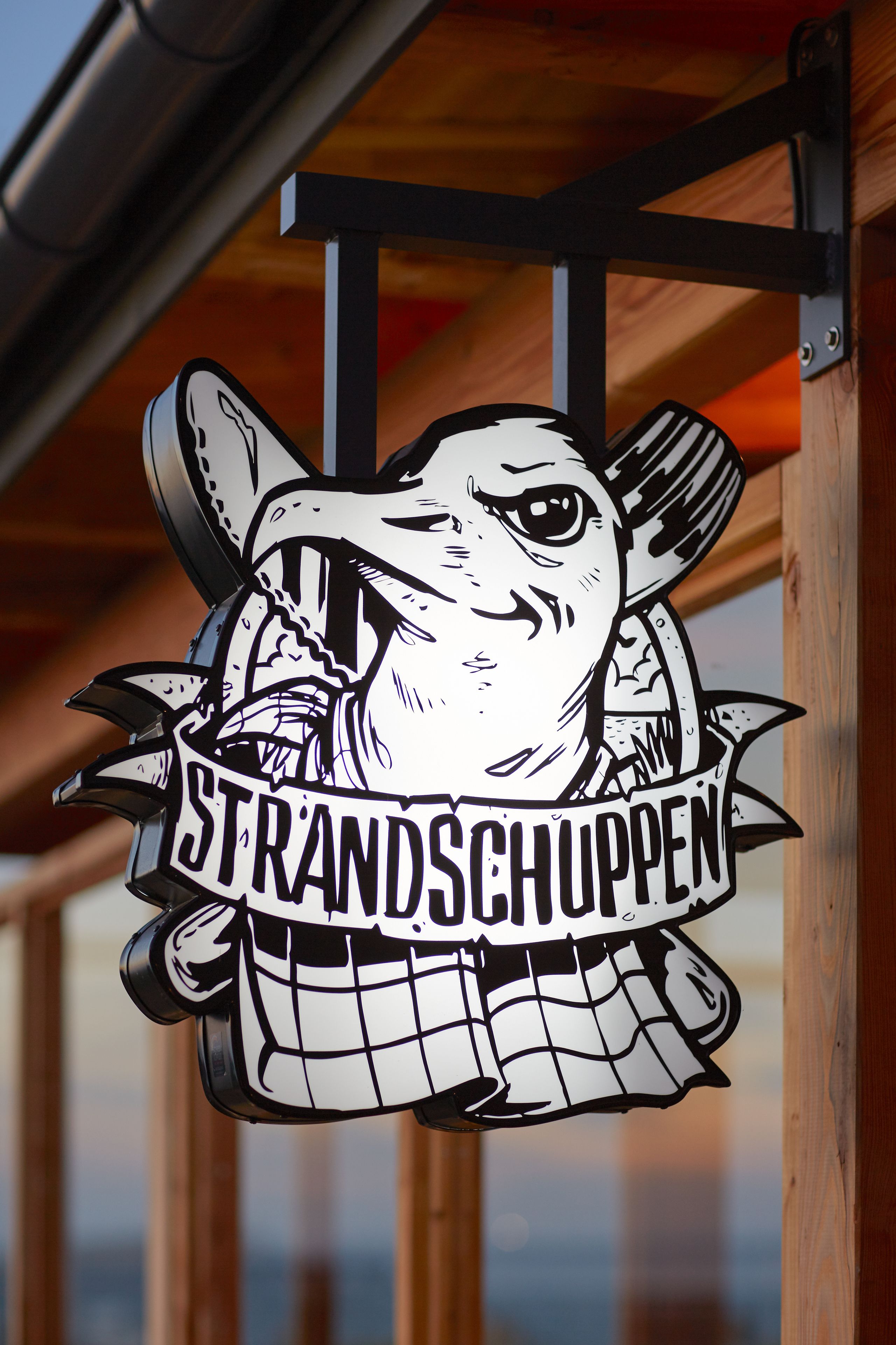 Un logotipo con un pájaro y el texto 'STRANDSCHUPEN'.