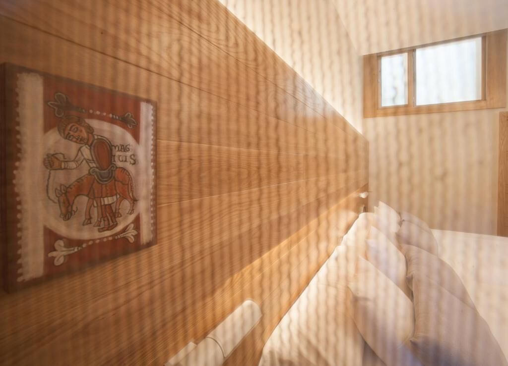 A room with wooden paneling, a window, and a wall-mounted artwork.