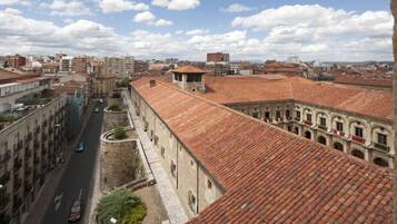 Edifici històric amb un pati interior, teulada de teules vermelles i un carrer al fons.