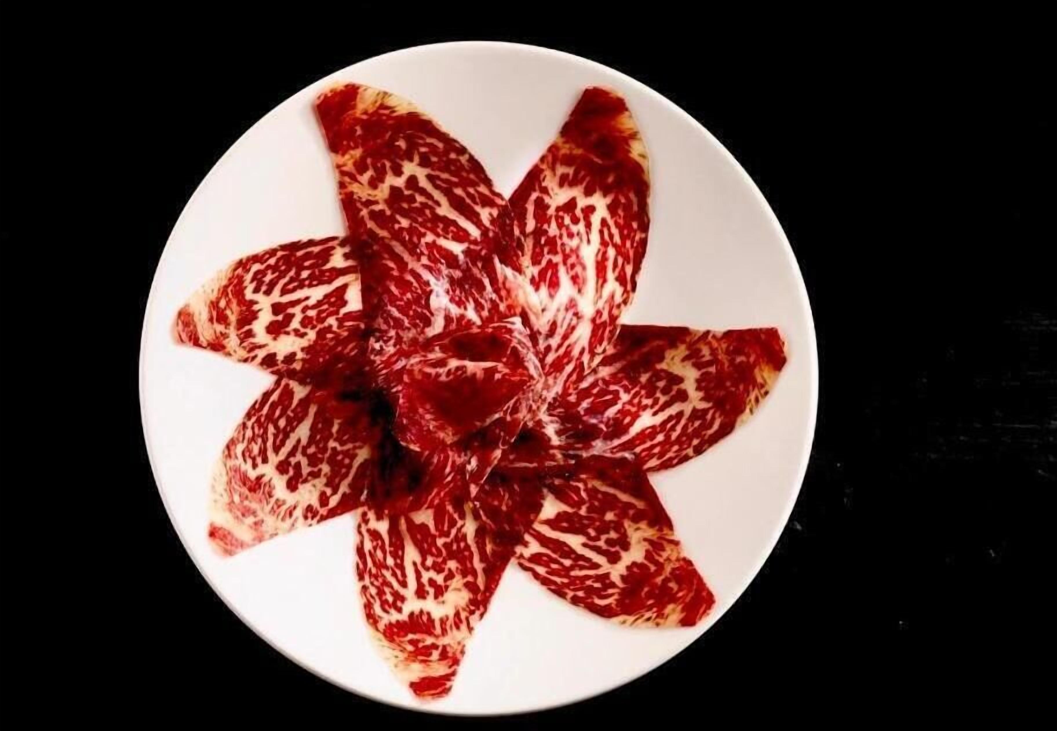 A plate of patterned meat slices arranged in a flower shape.