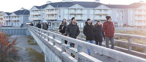 A pedestrian bridge with a view of a row of multi-story buildings with balconies.