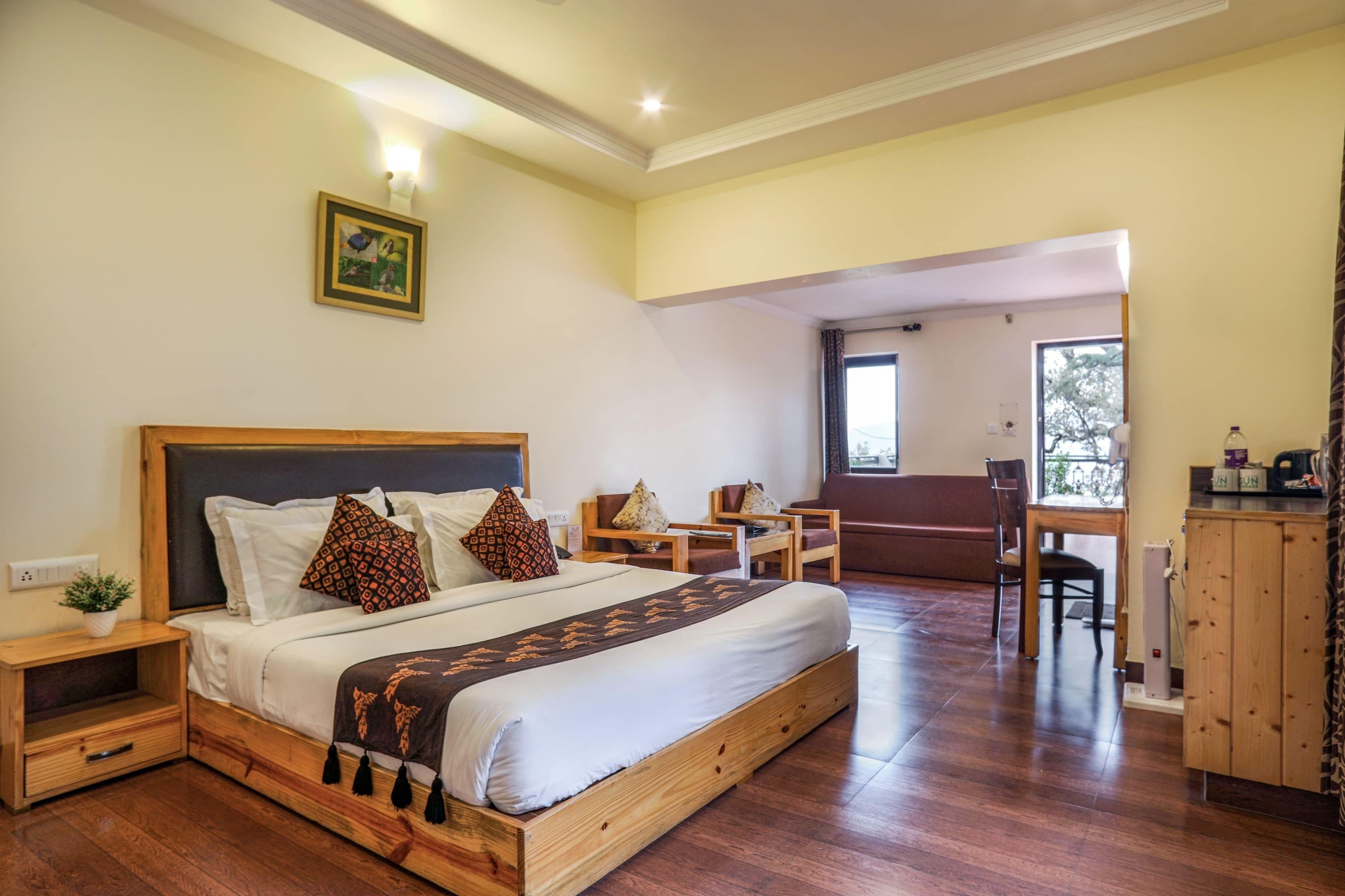 A spacious bedroom with a large bed, bedside tables, a desk, and a chair.