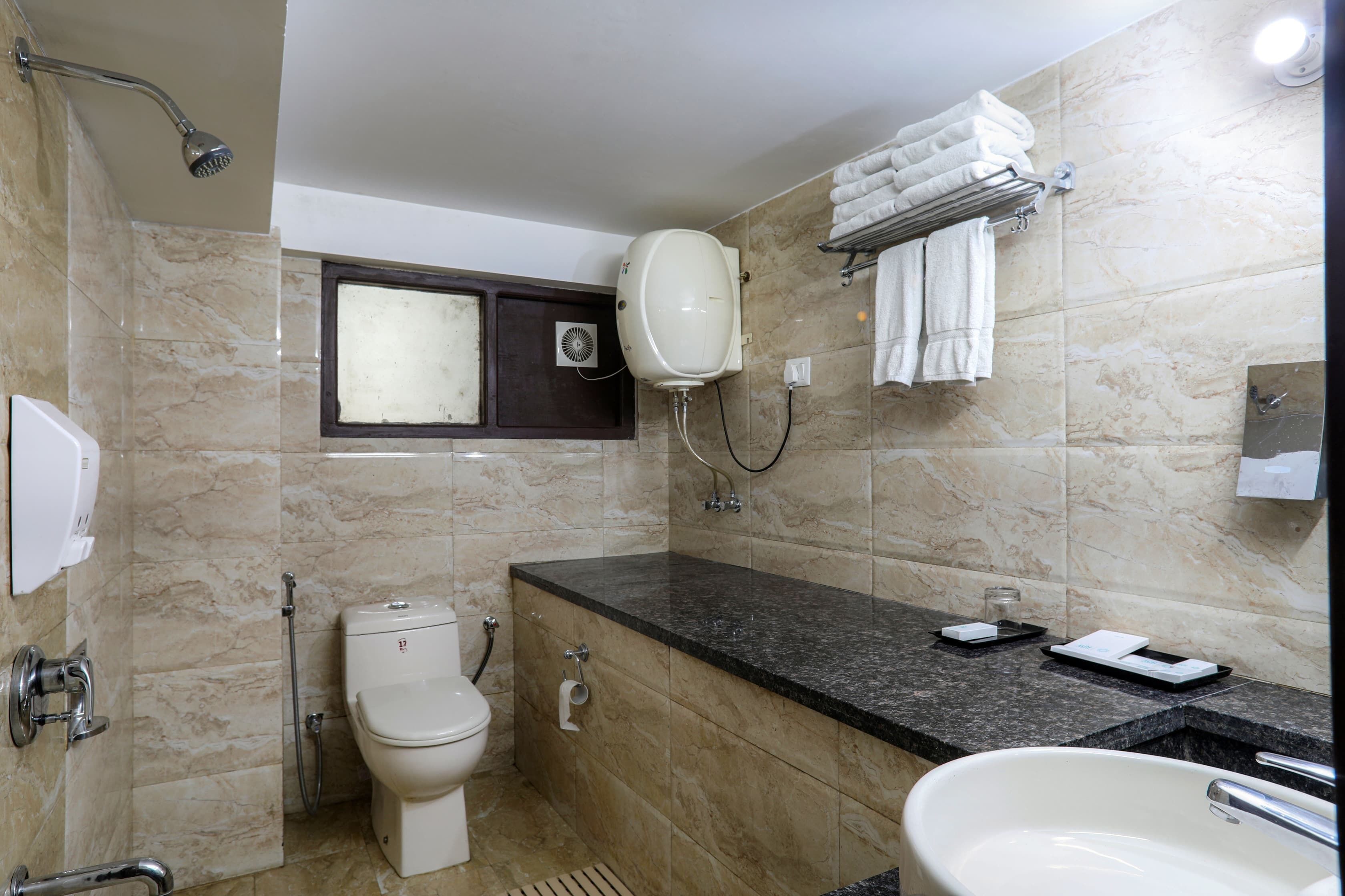 A bathroom with a toilet, sink, and shower.