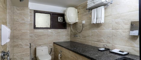 A bathroom with a toilet, sink, and shower.