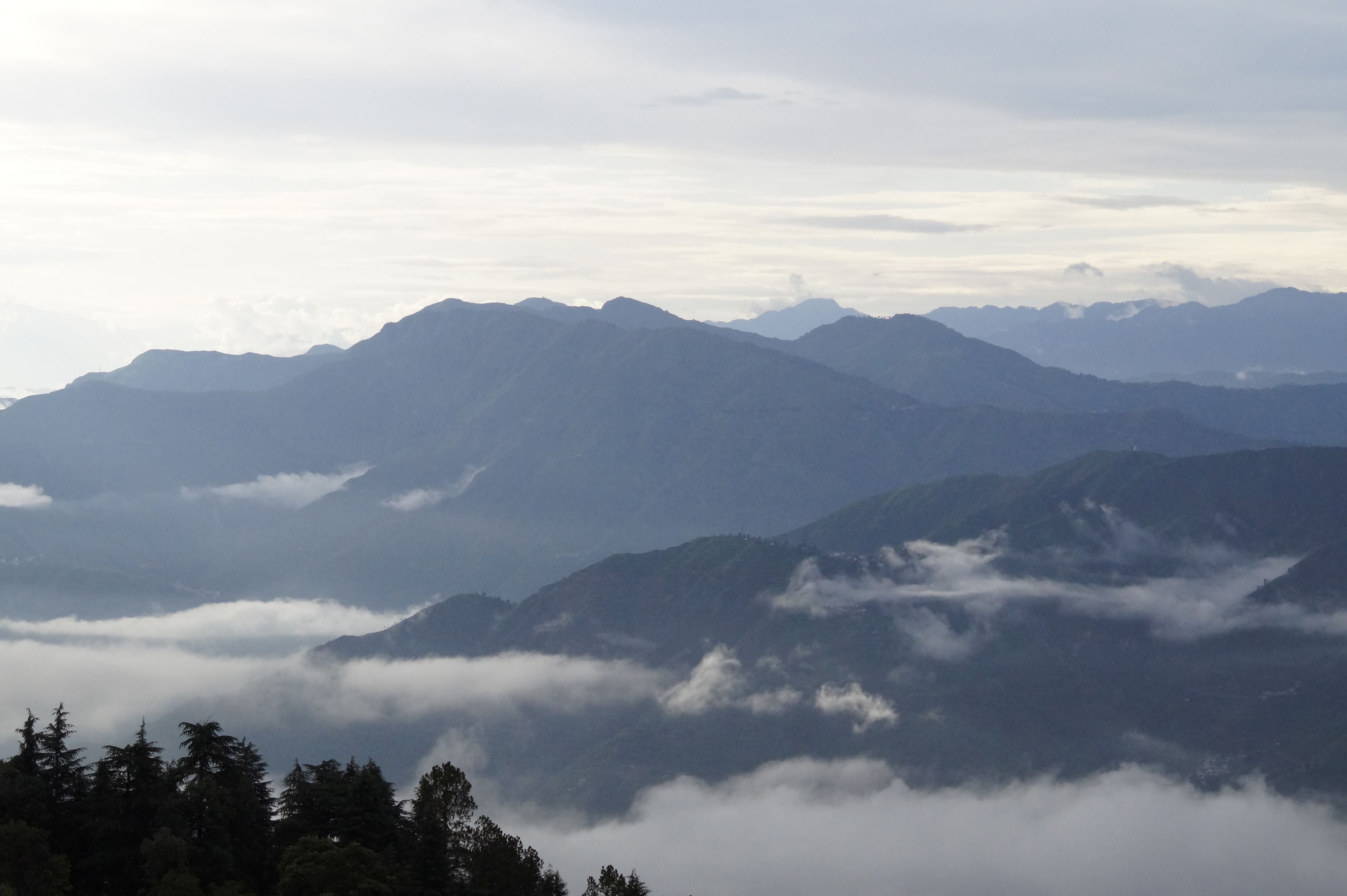 A mountainous landscape with multiple peaks and a valley below.