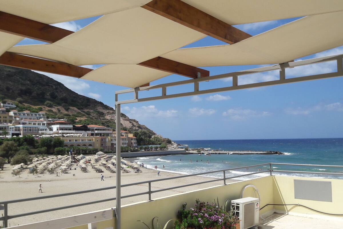 Un balcon avec vue sur une plage et l’océan.