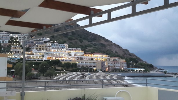 A coastal hotel with multiple stories, balconies, and a view of the sea. - Orange Fodele (Malevizi)
