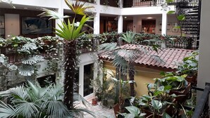 A multi-level atrium with numerous potted plants, a central staircase, and a tiled floor. - Solitaire Hotel & Boardinghouse Berlin (Berlin)