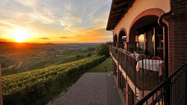 A building with a balcony overlooking a vineyard during sunset. - Tota Virginia Antico Podere (Serralunga d'Alba)