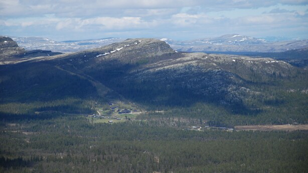 A mountainous landscape with a valley and a small settlement. - Skjerdingen Høyfjellshotel (Ringebu)