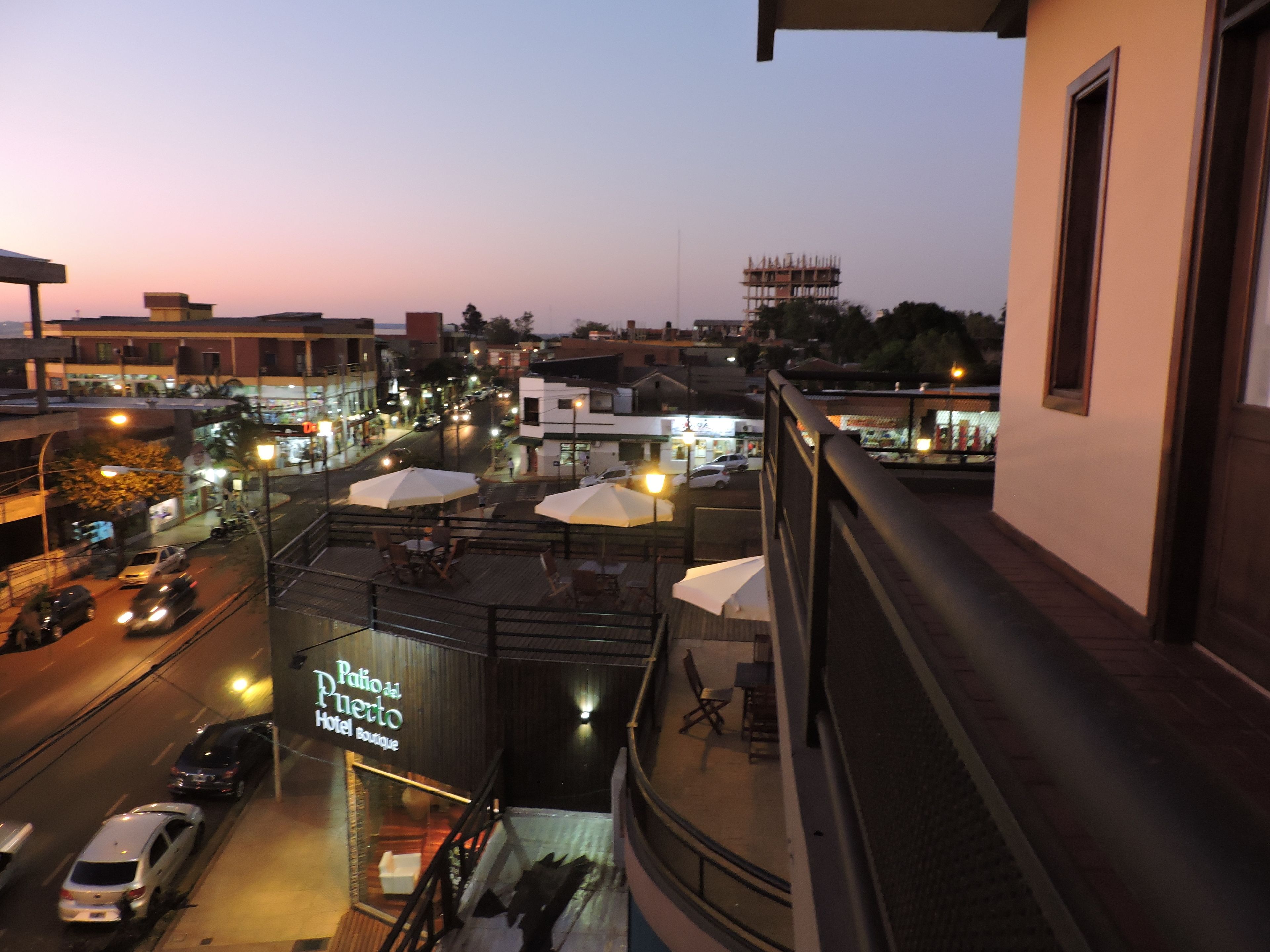 Un hotel con terraza y vistas a la calle.