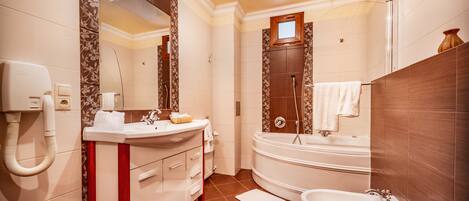 A modern bathroom with a sink, vanity, bathtub, and bidet.