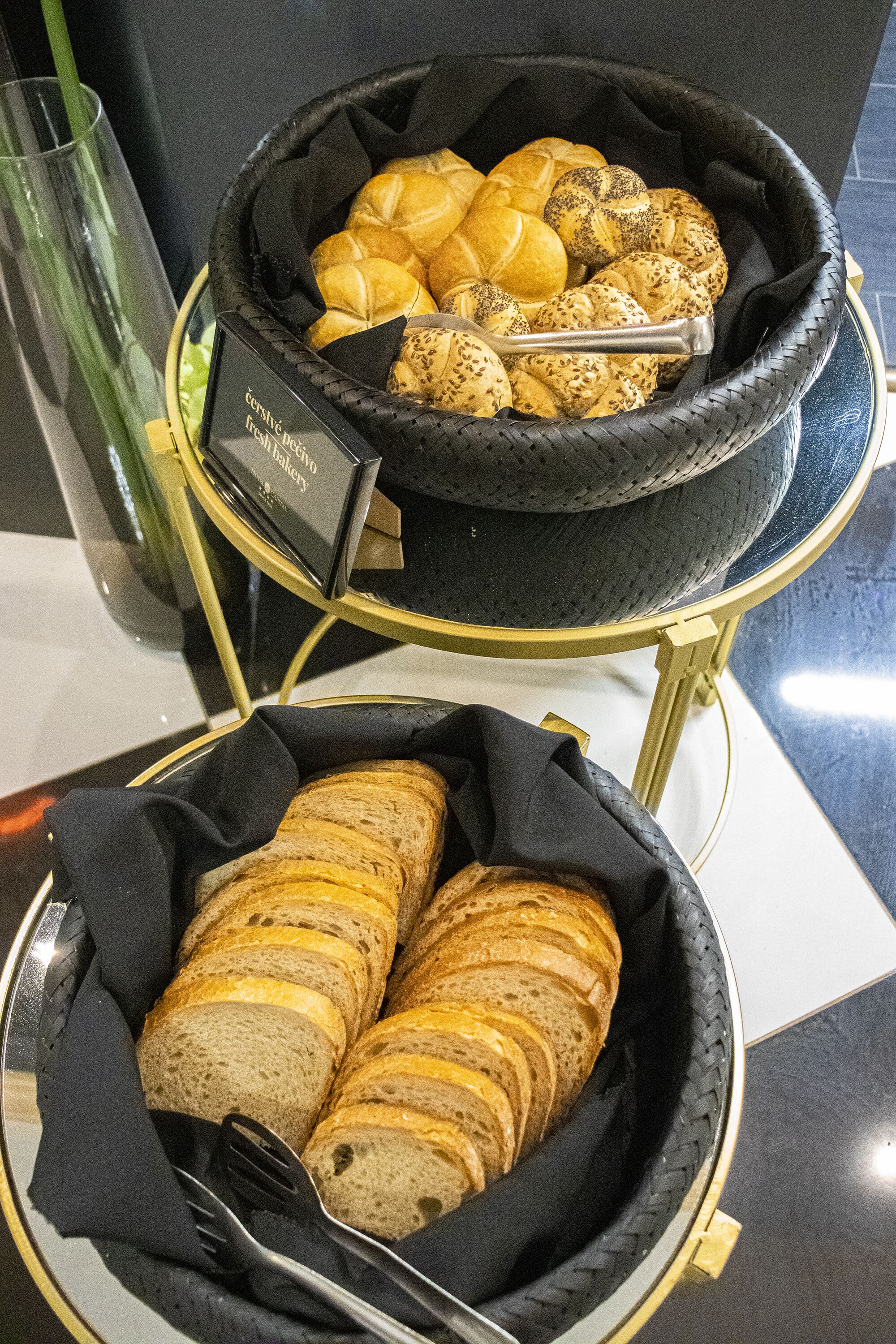 Una cesta con pan variado y un cartel que indica una panadería.