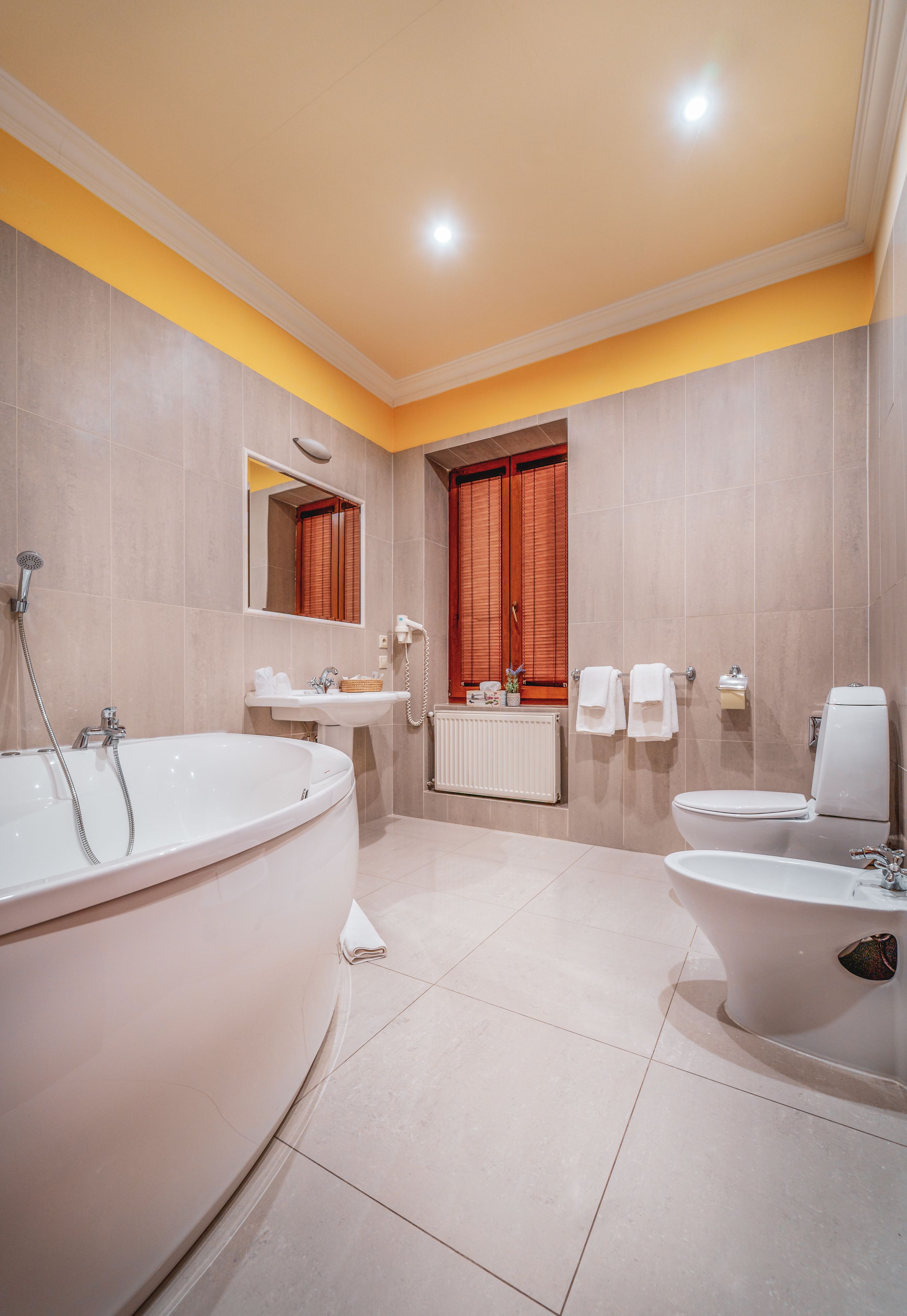A modern bathroom with a large bathtub, a toilet, a sink, and a shower.